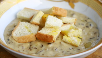 Creamy soup topped with slices of bread.