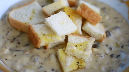 Creamy soup topped with slices of bread.
