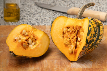 Fresh Acorn Squash and a slice on a cutting board close up