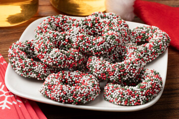 Plate with traditional Dutch Chocolate Christmas rings stuffed with fondant and covered with colorful sprinkles