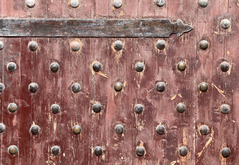 Detail of old wooden gate leaf part. Ancient wood door with metal rivets in Qaitbay Citadel, Alexandria, Egypt
