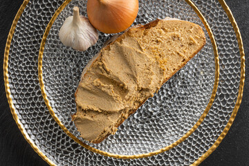 Liver pate on the bread on the beautiful christmas plate besaides onion and garlic close up banners...