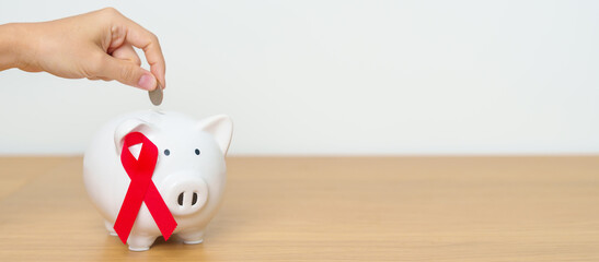 December World Aids Day, acquired immune deficiency syndrome, Red Ribbon with Piggy Bank for...