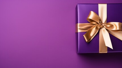 Purple gift box with gold ribbon on gradient background with copy space for text - holiday or Christmas present concept