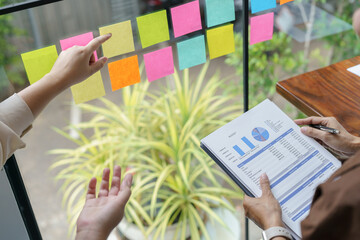Business People working on sticky notes creative writing down ideas on post it notes professional investor start up project business.