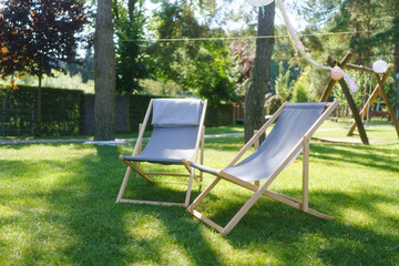 Garden loungers in the garden, in the shade under the trees. Outdoor garden furniture.