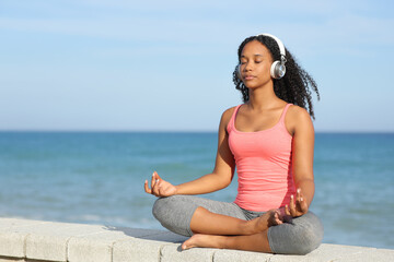 Fototapeta na wymiar Black yogi doing yoga listening audio guide
