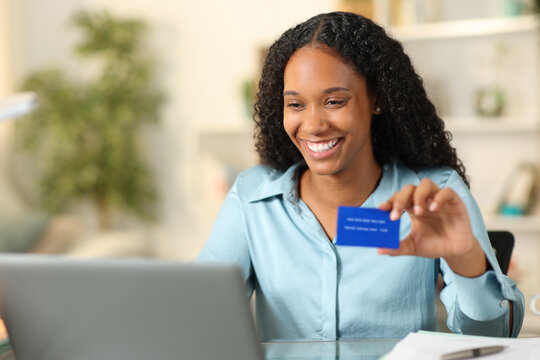 Happy black businesswoman buying online at home