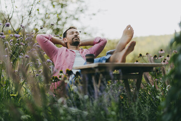 Relaxed man sitting in the garden with feet on table. Father having moment to himself while his kids are in school.