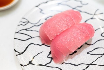 Close up of chutoro sushi on white ceramic plate. Raw medium fatty bluefin tuna meat sushi. Traditional Japanese original style food.