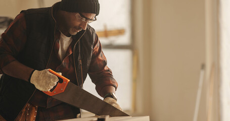 DIY carpenter using a saw to cut wood for his home renovation work