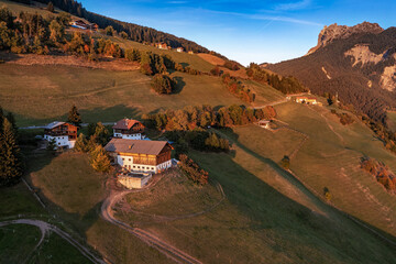 Santa Maddalena, Italy - Aerial panoramic view of Santa Maddalena village at sunset. Autumn scenery with traditional tyrolean houses, mountain peaks at background on a sunny afternoon at South Tyrol