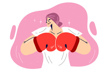 Woman in boxing gloves threateningly connects fists to cause fear or challenge opponent to fight