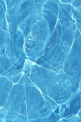 Defocus blurred transparent blue colored clear calm water surface texture with splashes reflection. Trendy abstract nature background. Water waves in sunlight with copy space. Blue watercolor shine.