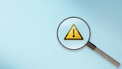 Fotobehang magnifier glass with yellow triangle caution warning sign on blue background. Attention, Warning,alert icon,caution dangerous concept. Root cause analysis or solving problem © Celt Studio