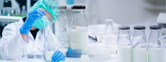 Expert nutritionist hold milk bottle delves quality analysis in laboratory of nutrition, lactose, protein fat percentage, test dairy product for allergic. Utilizing microbiology and bacterial process.