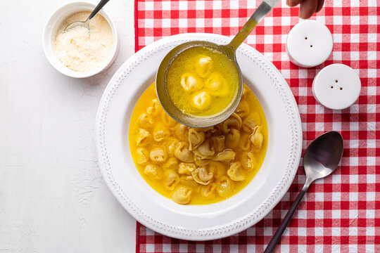 A ladle with homemade beef and chicken or capon broth with tortellini. Pasta. soup, originally from the Italian region of Emilia, Bologna. Stuffed with a mix of meat, prosciutto, parmesan cheese.
