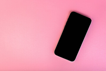 Smartphone with black screen on pink background with copy space.