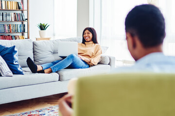 cheerful african american hipster girl satisfied with resting at modern interior living room