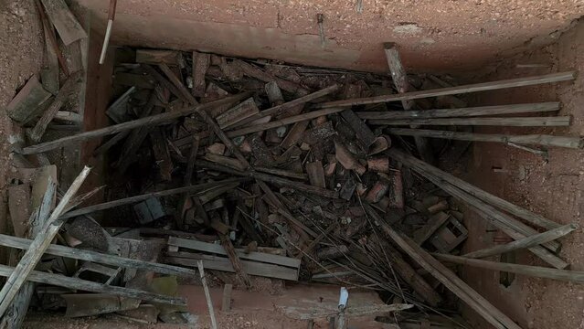 Aerial birdseye rising from abandoned tool shed with debris and no roof, Spain