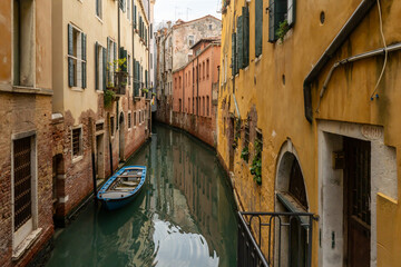 Channel in Venice - boat and old town houses
