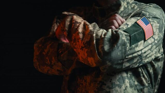 American soldier crossing arms on chest, USA flag patch on military uniform