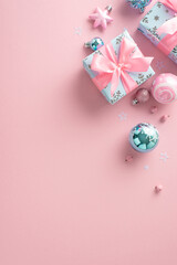 New Year's chic in a girlish theme. Overhead vertical photo of baubles, shimmering decor, elegant gift boxes, mistletoe berries on tender pastel pink backdrop, allowing for text or promotional content