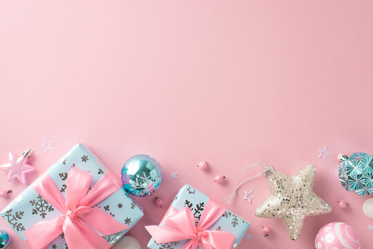 Chic festive winter soirée adorned with stylish ornaments motif. Top view image of balls, sparkling star, feminine gift parcels, mistletoe berries on pastel pink surface with space for text or promo