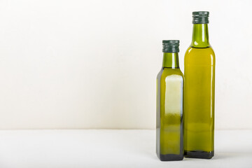 Olive oil in a bottle on texture background. Oil bottle and a bowl with branches and fruits of olives. Place for text. copy space. cooking oil and salad dressing.