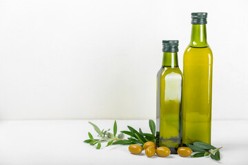 Olive oil in a bottle on texture background. Oil bottle and a bowl with branches and fruits of olives. Place for text. copy space. cooking oil and salad dressing.