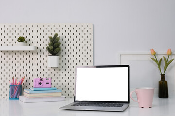 Laptop with blank white screen on office desk