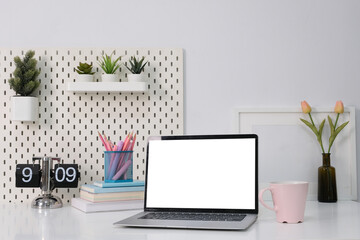 Laptop with blank white screen on office desk