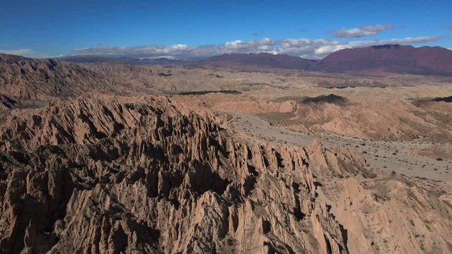 Drone shot flying over dramatic rock formations in the Quebrada de las Flechas in Salta, Argentina.