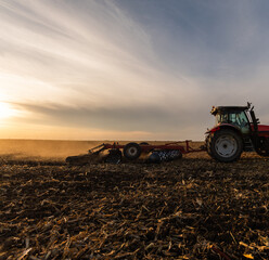Fototapeta premium Farmer preparing his field in a tractor