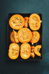 Autumn nutrition. Fresh pumpkin on a metal tray. On a dark stone background. Thanksgiving day.