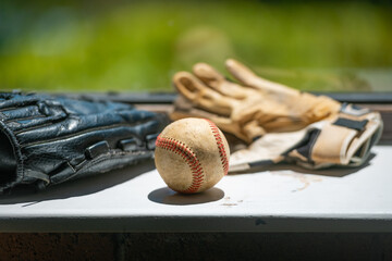 Old baseball ball, mitt and batting gloves, copy space.