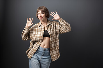 Beautiful  woman portrait  in in a plaid shirt and jeans on dark background