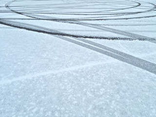 Dynamic car tread marks on the snow. Early winter. Energy and expression of movement. Black and...