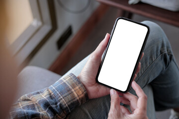 cell phone blank white screen mockup.hand holding texting using mobile on desk at office.background...