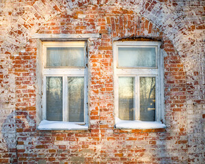 winter snow-covered window cornices on a old brick wall