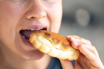 Detailed shot of a woman eating fresh bun.