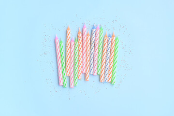 Multicolored birthday candles with Red glitter on blue background, Colorful candles party