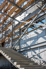 Construction of a building using scaffolding. Facade restoration work. Fragment of scaffolding and stairs
