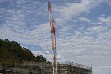 晴れた日の建築現場で、クレーンが操作されている風景