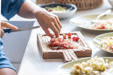 A woman cuts grapes on a cutting board.