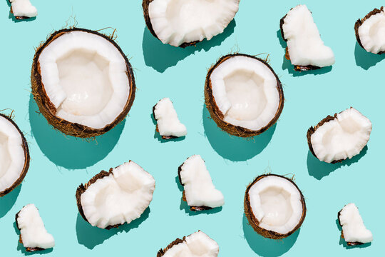 Broken slices of coconuts arranged against blue background