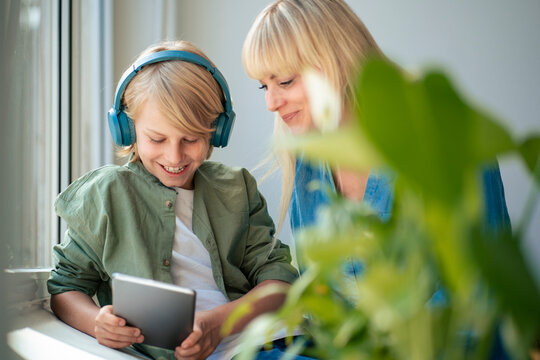 Smiling mother with son using tablet PC at home