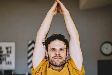 Motivated hipster guy doing yoga exercises during training