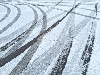 Dynamic car tread marks on the snow. Early winter. Energy and expression of movement. Black and...
