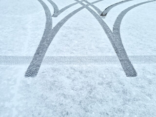 Dynamic car tread marks on the snow. Early winter. Energy and expression of movement. Black and...